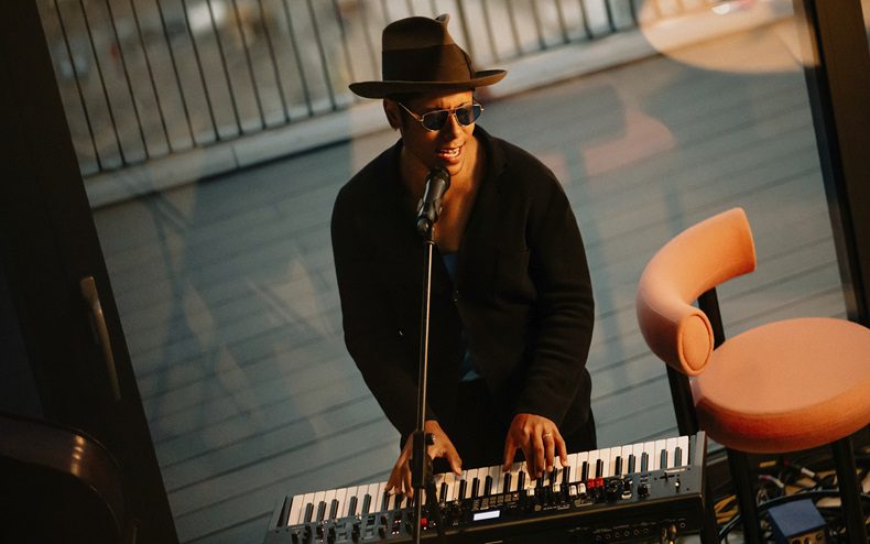 Reuben James performing with a microphone and keyboard