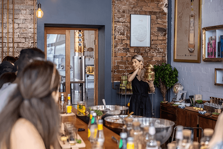 Seated guests watch as a distillery professional addresses them