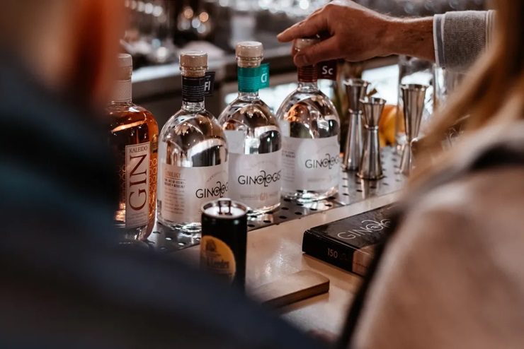 Three bottles of ginologist gin laid on a table - distilleries