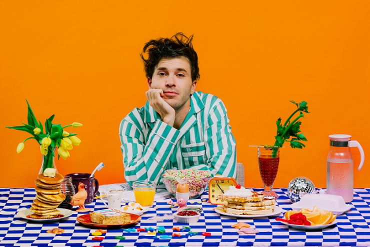 Matthew Mole seated at a table full of treats 