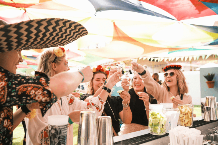 Friends dressed in Mexican attire toast their glasses