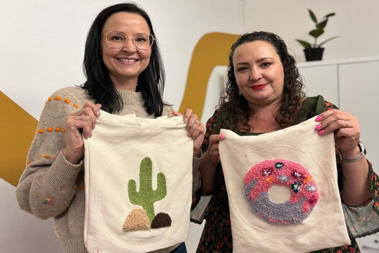 Two people hold up their needle-punched tote bags this weekend in Joburg