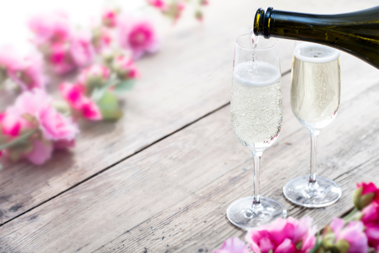 two glasses of bubbly surrounded by pink flowers