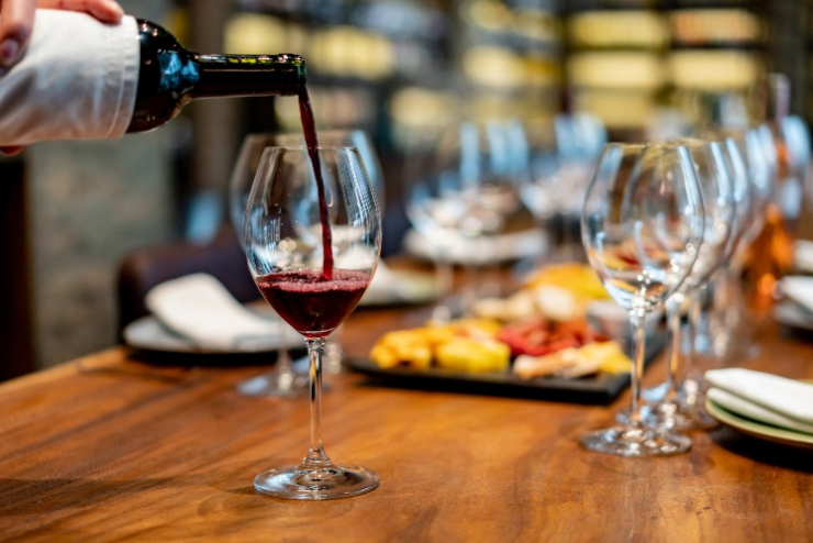 Wine being poured into a glass on a dining table