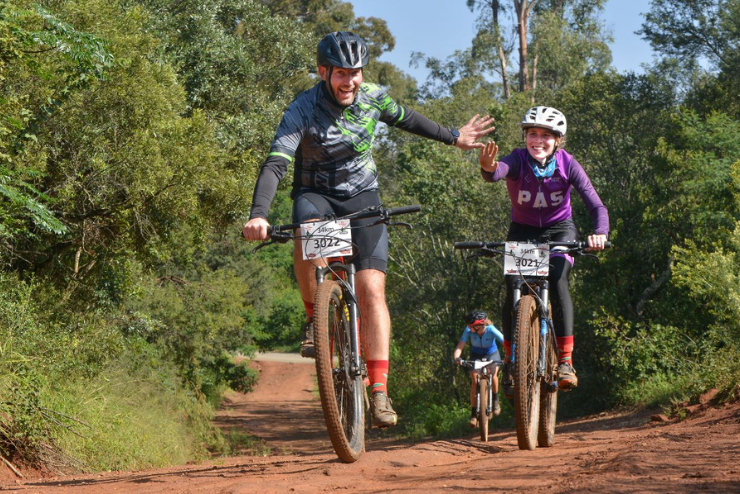 Two mountain bikers give each other a high five