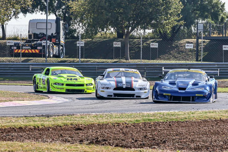 Three sports cars racing in the National Extreme Festival